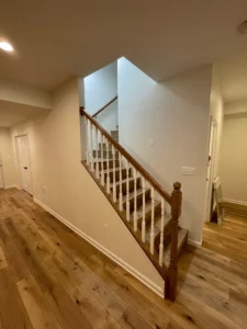 A picture of a room with wooden flooring and a stair