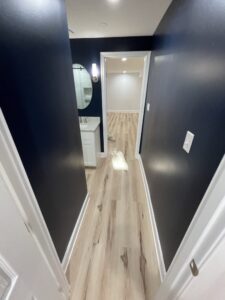 A dark blue bathroom with wooden flooring