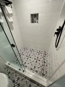 A shower area with a glass door