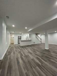 An empty basement with dark brown flooring