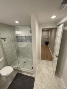 A glass shower in a white bathroom