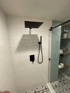 A black shower fixture at the white wall